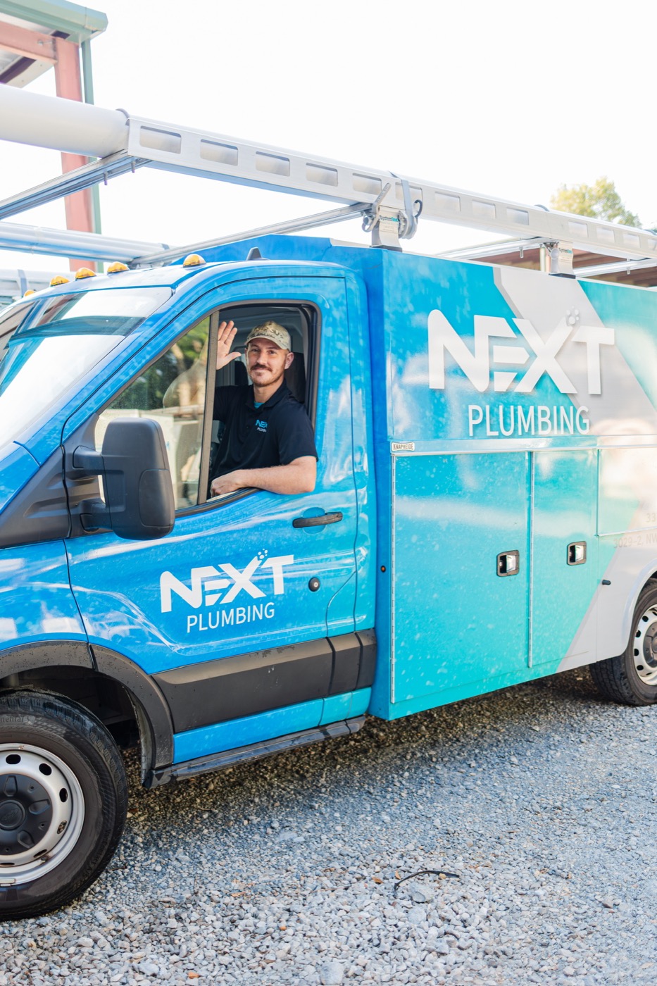 Next Plumbing team member arriving in a branded service van